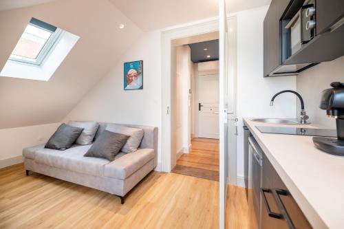 un salon avec un canapé dans une cuisine dans l'établissement Chez Lilly - Neuf - Haut de Gamme - Tram - Proche centre-ville - Tout confort, à Strasbourg