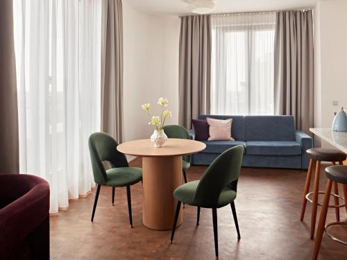 a living room with a table and chairs and a couch at Numa Berlin Drift in Berlin