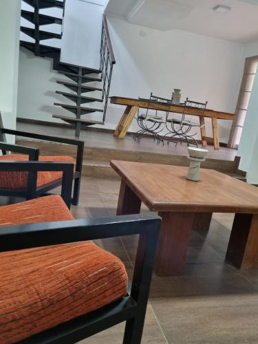 a room with wooden tables and chairs and stairs at Hornero House in San Antonio de Areco