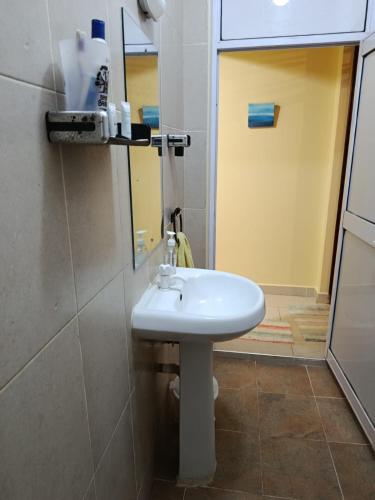 a bathroom with a white sink and a mirror at Enkan Naserian in Kilifi