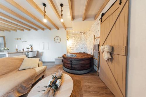 a living room with a large wooden door and a barrel at Instants Précieux - Love Room in Arvert