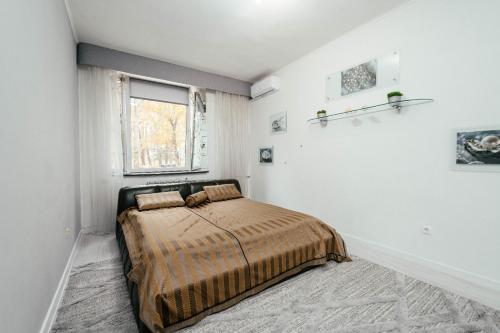 une chambre avec un lit dans une pièce blanche dans l'établissement Central Apartment Facing the Cathedral, à Chişinău