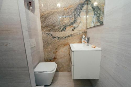 une salle de bain avec des toilettes blanches et un lavabo dans l'établissement Central Apartment Facing the Cathedral, à Chişinău