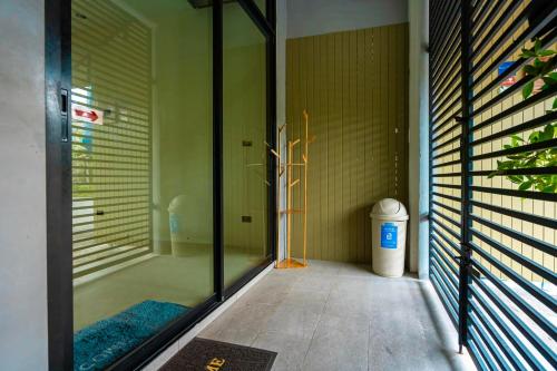 een badkamer met een douche met een glazen deur bij Ellie House Phuket Old Town in Ban Rangeng