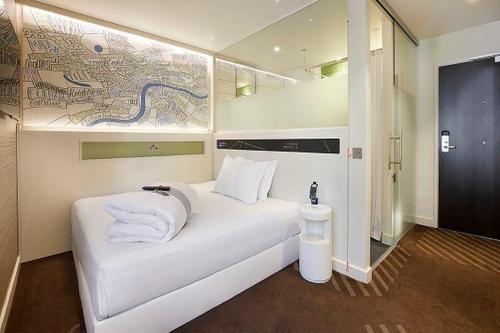 uma cama branca com toalhas num quarto em hub London - Shoreditch em Londres