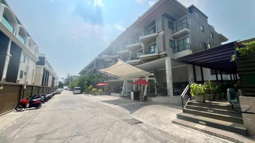 a street with a building with cars parked next to it at The Charm Resort Phuket in Patong Beach
