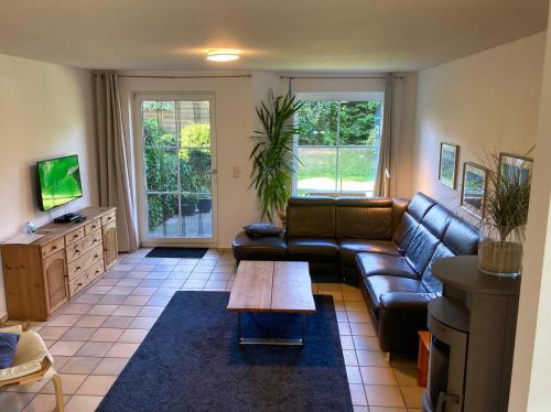 a living room with a leather couch and a coffee table at Ferienhaus Mehler - Heiligenhafen in Heiligenhafen