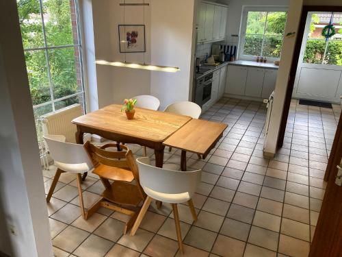 a kitchen with a wooden table and white chairs at Ferienhaus Mehler - Heiligenhafen in Heiligenhafen