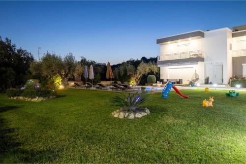 een tuin met een huis en een speeltuin bij Mika Villa in Afantou