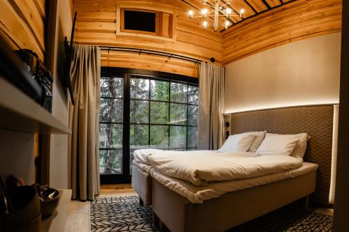 a bedroom with a bed and a large window at Vaattunki Wilderness Resort in Rovaniemi