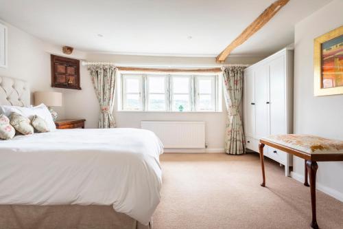 une chambre avec un grand lit blanc et une fenêtre dans l'établissement Woodlea Cottage, à Moffat