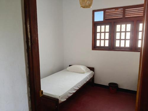a small bed in a room with a window at ANGEL VILLA , Place with nature and care in Midigama West