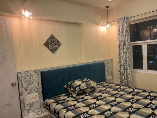 a bedroom with a bed with a blue head board at FAMILY ONLY -No unmarried couple allowed #2 in Thane