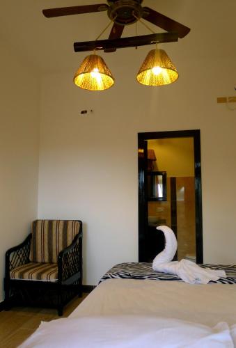a bedroom with a swan on the bed and a chair at Hotel Sotavento in Montañita