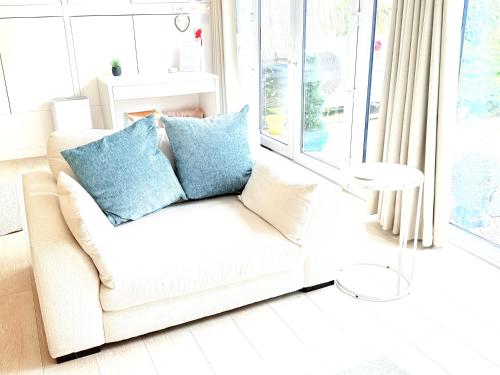a white couch with blue pillows in a living room at The Retreat Studio in Carlisle