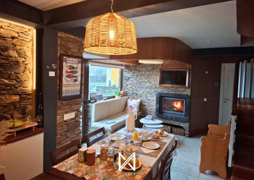 Un comedor con mesa y chimenea. en MyStay - Campus Natura, en Arganil