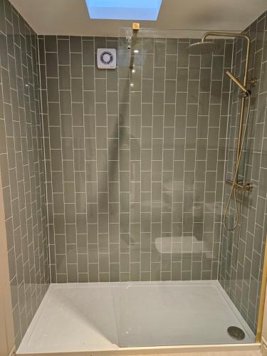 a bathroom with a shower with a tiled wall at Newditch Farm - BRS Airport in Bristol