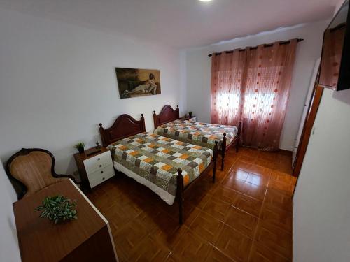 Una habitación con dos camas y una mesa dentro. en Alojamentos Altamira, 