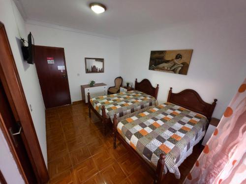 a room with two beds in a room at Alojamentos Altamira 