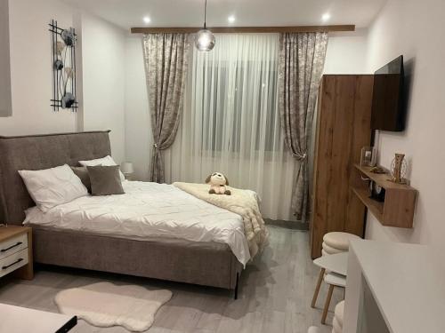 a bedroom with a bed with a dog sitting on it at INNA Studio Rin Residence in Bucharest