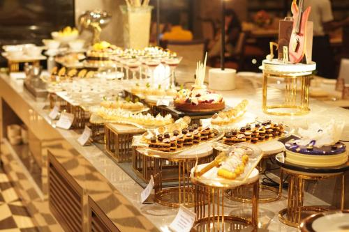 Una línea de buffet con muchos tipos diferentes de postres. en Wyndham Grand Udaipur Fateh Sagar Lake, en Udaipur