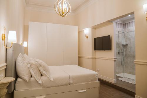 a white bedroom with a bed and a tv at Spadalux Apartment - 3 BR 4 Bath Luxury Apt in Florence