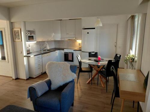 een keuken en woonkamer met een tafel en stoelen bij Viihtyisä huoneisto Ivalossa in Inari