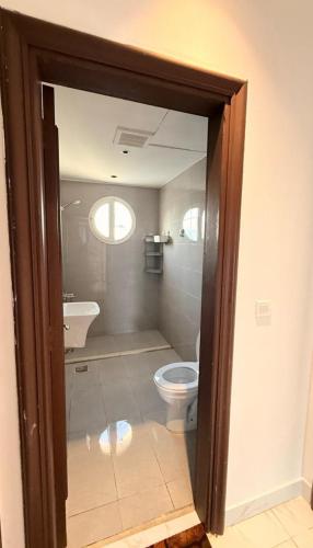 a bathroom with a toilet and a sink at فيلا درة العروس in Dahaban