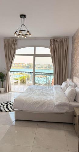 a bedroom with a large bed and a balcony at فيلا درة العروس in Dahaban