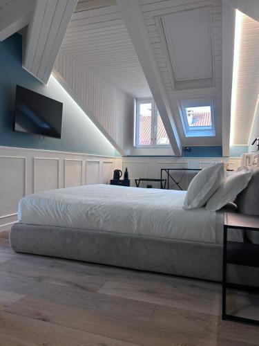 a bedroom with a large bed and two windows at Q suites urban relais in Turin