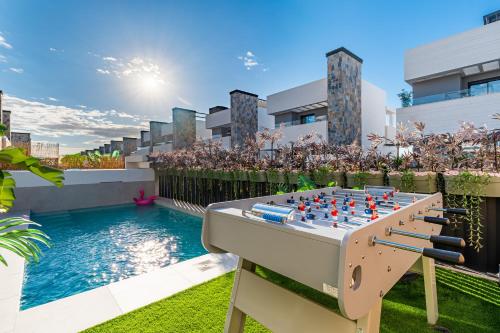 a chess board on a table next to a pool at Villa de lujo con jacuzzi, cine, billar y futbolín in Las Casicas