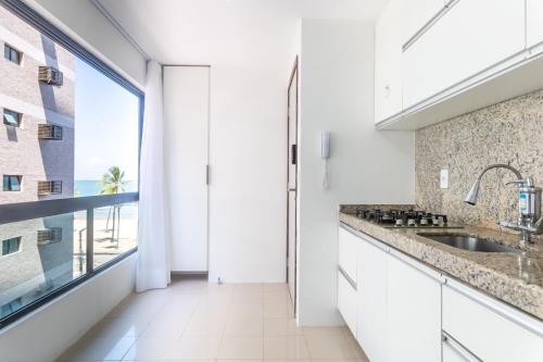 a kitchen with a sink and a large window at Place Beira Mar in Recife