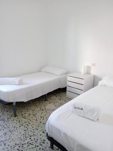a bedroom with two beds and a dresser at Tamariua L2, apartamento cerca de la playa del Pas in Port de la Selva