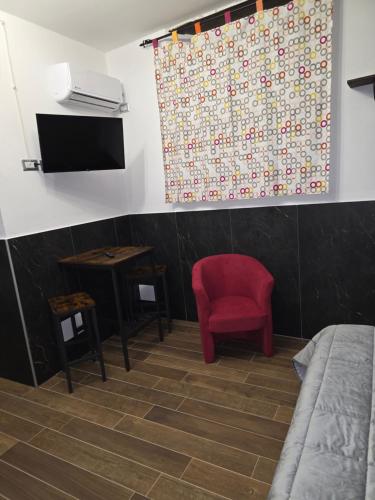 een kamer met een bed en een rode stoel bij L' Arco Rosa in Alatri