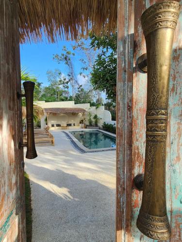 an open door to a house with a swimming pool at Villa Solara in Uluwatu
