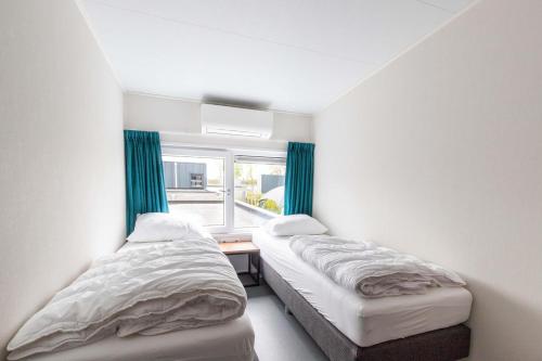 Dos camas en una habitación con ventana. en Zindering Renesse, en Renesse