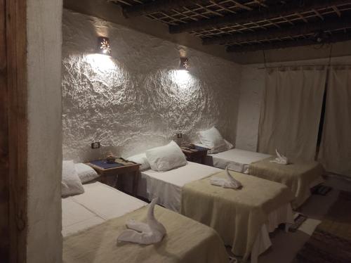 a room with three beds with swans on them at Esewan siwa oasis in Siwa