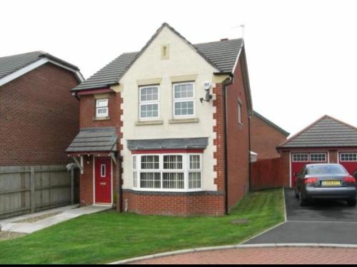 a red brick house with a red door at The Nightingale in Lower Darwen