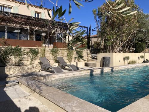 une piscine avec des chaises longues à côté d'un bâtiment dans l'établissement Chambres & Table d'Hôtes Au Soleil du Bonheur, à Lafare