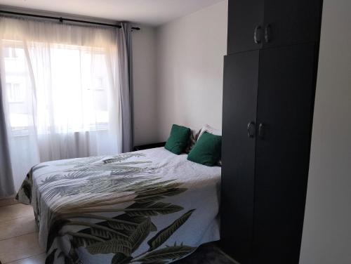 ein Schlafzimmer mit einem Bett und einem großen Fenster in der Unterkunft Whispering Waves SummerSands in Durban