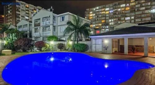 ein großer blauer Swimmingpool vor einem Gebäude in der Unterkunft Whispering Waves SummerSands in Durban