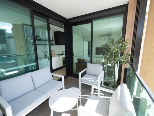 a living room with a couch and a table at Villa Solara - A Tranquil Light Filled Home in Melbourne