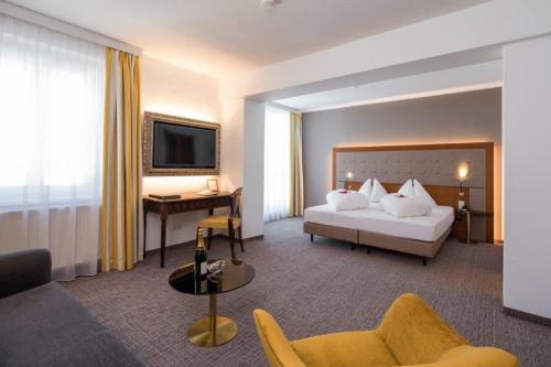 een hotelkamer met een bed en een bureau bij GORITSCHNIGGs Hotel - Self Check-In in Velden am Wörthersee