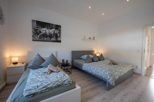 2 Betten in einem Schlafzimmer mit 2 Lampen in der Unterkunft HagenStay Eilpe 2 in Hagen