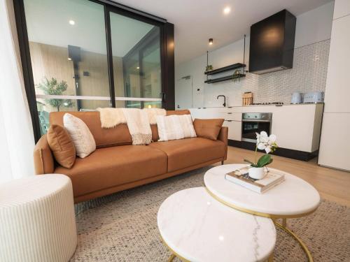 a living room with a couch and a table at Villa Solara - A Tranquil Light Filled Home in Melbourne