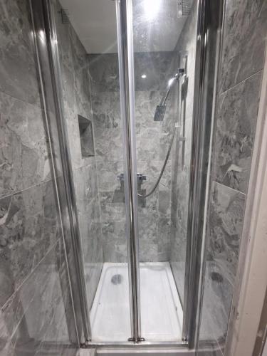 a bathroom with a shower with a tub at The Nightingale in Lower Darwen