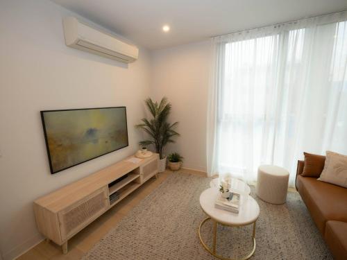 a living room with a flat screen tv on a wall at Villa Solara - A Tranquil Light Filled Home in Melbourne