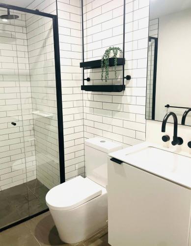 a white bathroom with a toilet and a sink at Villa Solara - A Tranquil Light Filled Home in Melbourne