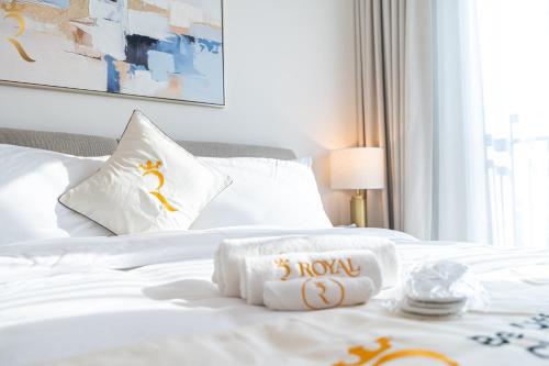 a white bed with a hotel towel on it at Stylish Yas Studio- Modern Urban Stay in Abu Dhabi
