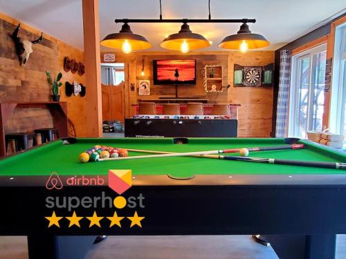 a pool table in a living room with a bill at The Western Spa Sauna Bar & Billiards in Valcartier Station